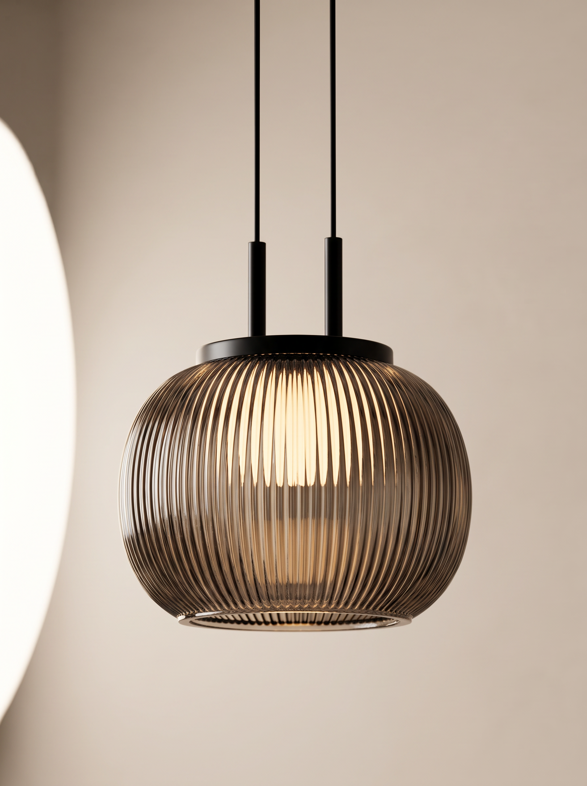 Filano ribbed glass pendant lit, hanging from black cord