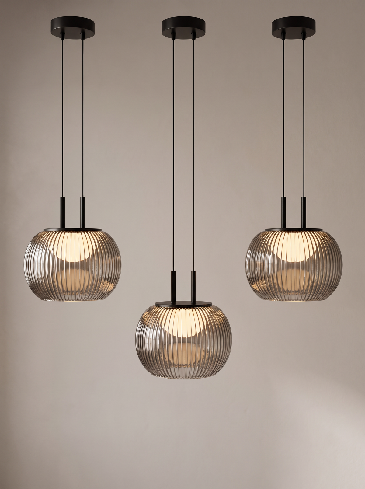 Three Filano ribbed glass pendants in a row at staggered heights